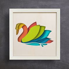 a colorful paper cut swan sitting on top of a blackboard