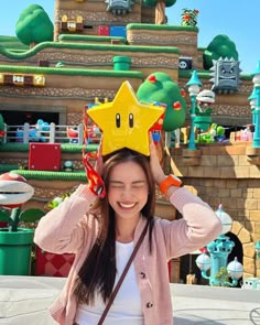 a woman with a star crown on her head in front of a mario kart land theme park