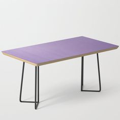 a wooden table with black metal legs and a pink design on the top, against a white background