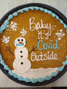 a baby it's cold outside cake with frosting and a snowman on top