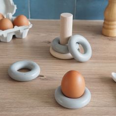 an egg sitting on top of a wooden table next to other toy eggs and toys