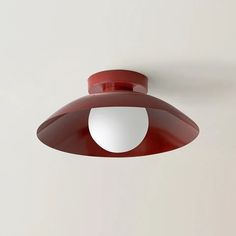 a red light hanging from the side of a white wall