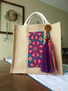 a bag with a tassel hanging from it's side on top of a table