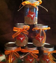 a stack of mason jars with orange ribbon around the top and an arrow on each jar