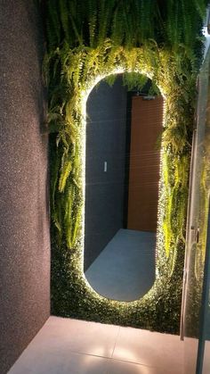 a mirror that is sitting in the middle of a room with plants growing on it