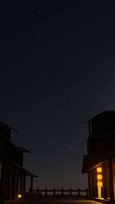 two buildings at night with the moon in the sky and stars shining down on them