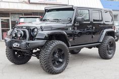 a black jeep parked in front of a building