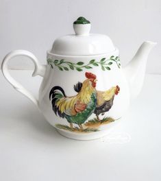 a tea pot with two roosters painted on it