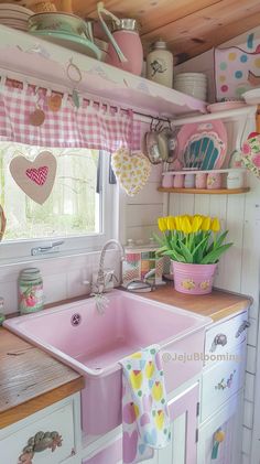 a pink kitchen sink sitting under a window