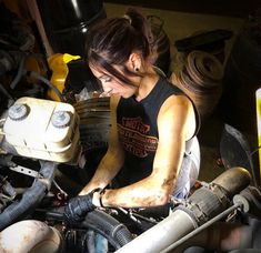 a woman working on an engine in a garage