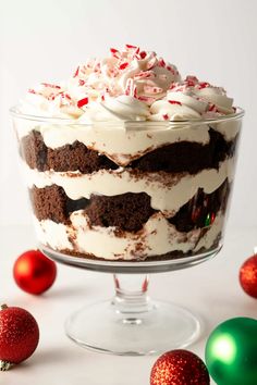 a large cake with white frosting and candy canes on the top in a glass dish