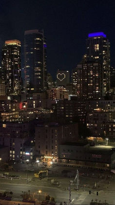 the city skyline is lit up at night, with a message written in front of it