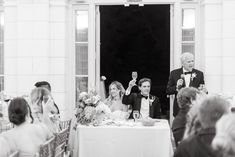 the bride and groom are standing at the entrance to their wedding reception in black and white