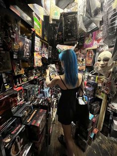 a woman with blue hair is looking at items on display in a store that sells merchandise