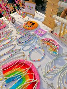 a table topped with lots of different types of beads and necklaces on it's sides