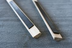 two pieces of wood sitting next to each other on a table with black and white stripes