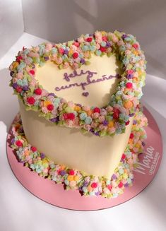 a heart shaped cake with flowers on top