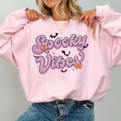 This super-soft fleece-lined Spooky Vibes Sweatshirt features a cute Halloween design - perfect for the chilly days of fall! Printed on Gildan unisex sweatshirts for the ultimate in cozy comfort. Please check the size charts for the perfect fit! Details: ✔ 50% ethically grown cotton, 50% polyester ✔ Medium-heavy weight fabric for the perfect amount of warmth ✔ Premium DTG prints - no peeling or cracking ✔ Classic fit in your regular size ✔ Easy care: Machine washable, maintains shape and color ? Fall Kawaii Style Sweatshirt With Cartoon Print, Kawaii Cartoon Print Sweatshirt For Fall, Trendy Fall Sweatshirt With Character Print, Trendy Character Print Sweatshirt For Fall, Kawaii Letter Print Sweatshirt For Fall, Pink Cartoon Print Sweater For Fall, Novelty Long Sleeve Sweatshirt, Fun Oversized Sweatshirt For Fall, Pink Halloween Sweatshirt For Streetwear