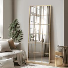 a living room with a couch, mirror and potted plant on the floor in front of it