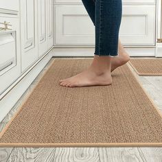 a woman standing on top of a rug in a room