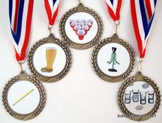 three medals with different items on them hanging from the same medal ribbon as if they were for sports