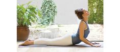 a woman is doing yoga in front of a glass door and potted plant on the floor