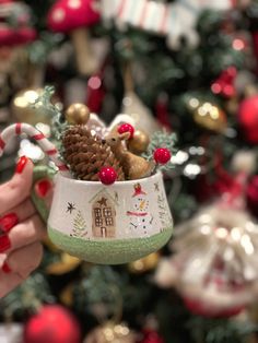 a person holding a mug with christmas decorations on it