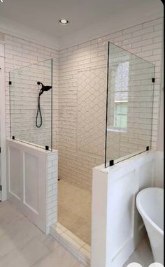 a bathroom with white tile and black trim on the shower door, tub and sink