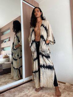 Make the ideal style statement with this stunning Swan - Long Kimono Robe. Adorned in a tie-dye unique technique, this lightweight cover-up has long sleeves and two pockets. Throw on over any outfit for a chic and floaty finish. Whether it be dressing up with heels for a night out or pairing with a plain cami for a summer's day, the possibilities are endless! Features: Lightweight feel Very comfortable Breathable Tie-dye Handmade Oversized fit Long sleeves Removable waist tie closure Two pockets Festival Kimono Outfit, Kimono Boho, Kimono Outfit, African Traditional Dresses, Tie Dye Maxi, Boho Kimono, Print Kimonos, Long Kimono, Tie Dye Dress