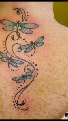 the back of a woman's neck with dragonflies on it