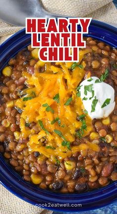 hearty lentil chili with sour cream in a blue bowl on a burloom cloth