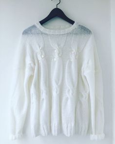 a white sweater hanging on a hanger