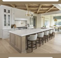 a kitchen with an island and bar stools next to it, in the middle of a large open floor plan