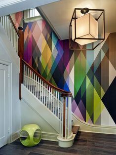 an image of a staircase with colorful wallpaper on the walls and below it is a light fixture