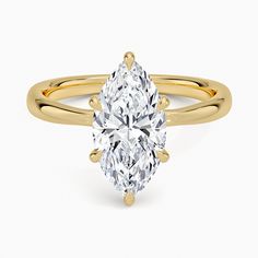 a yellow gold ring with a pear shaped diamond