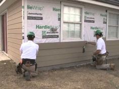 two men working on the side of a house with siding taped to it's sides