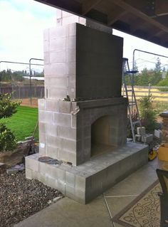 an outdoor fireplace is built into the side of a house