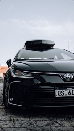 the front end of a black car with a license plate