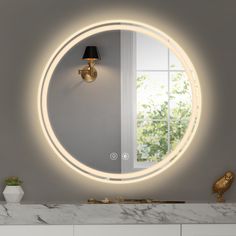 a bathroom with a round mirror on the wall and a lamp in front of it