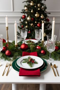 a christmas table setting with candles, plates and napkins