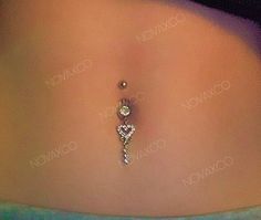 an image of a woman's stomach with a dangling navel ring on it