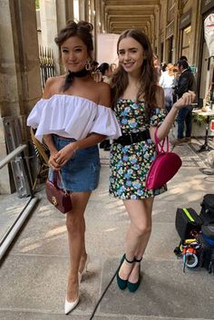 two women standing next to each other on a sidewalk