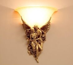 a wall mounted light with an angel on it