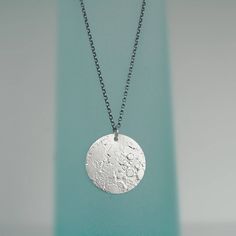 Silver Moon Necklace Handmade in fine silver (99.9% purity, slightly higher in purity than sterling silver & does not tarnish). Chain is sterling silver - 92.5% silver. Moon - 25mm diameter. The surface of the fine silver is molten to create crater like textures and shadows.  Available in a choice of finishes (see pics to compare): 1. Bright white, polished all over finish pendant and chain. 2. Oxidised* with a blackened finish and polished highlights on pendant and chain.  Each moon is handmade Everyday Silver Jewelry With Moon Phase, Everyday Silver Moon Phase Jewelry, Silver Moon Phase Jewelry For Everyday, Celestial Silver Oval Pendant Jewelry, Sterling Silver Circle Jewelry With Moon Phase, Silver Moon Phase Round Disc Jewelry, Moon Shaped Sterling Silver Necklace With Coin Pendant, Silver Moon Phase Disc Jewelry, Silver Moon Necklace With Coin Pendant