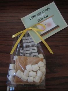 a bag filled with marshmallows sitting on top of a wooden table next to a tag