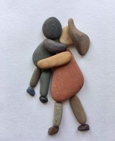 some rocks are stacked on top of each other in the shape of a person hugging