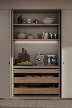 an open cupboard filled with lots of dishes and bowls on top of wooden flooring