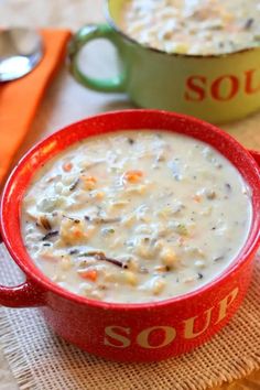 two red bowls filled with soup on top of a table