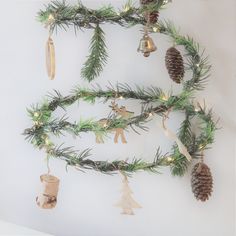 a christmas tree with ornaments hanging from it's branches and pine cones on top