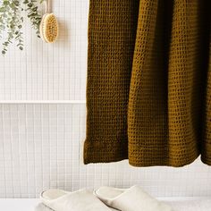 two pairs of slippers sitting on top of a bath tub next to a shower curtain